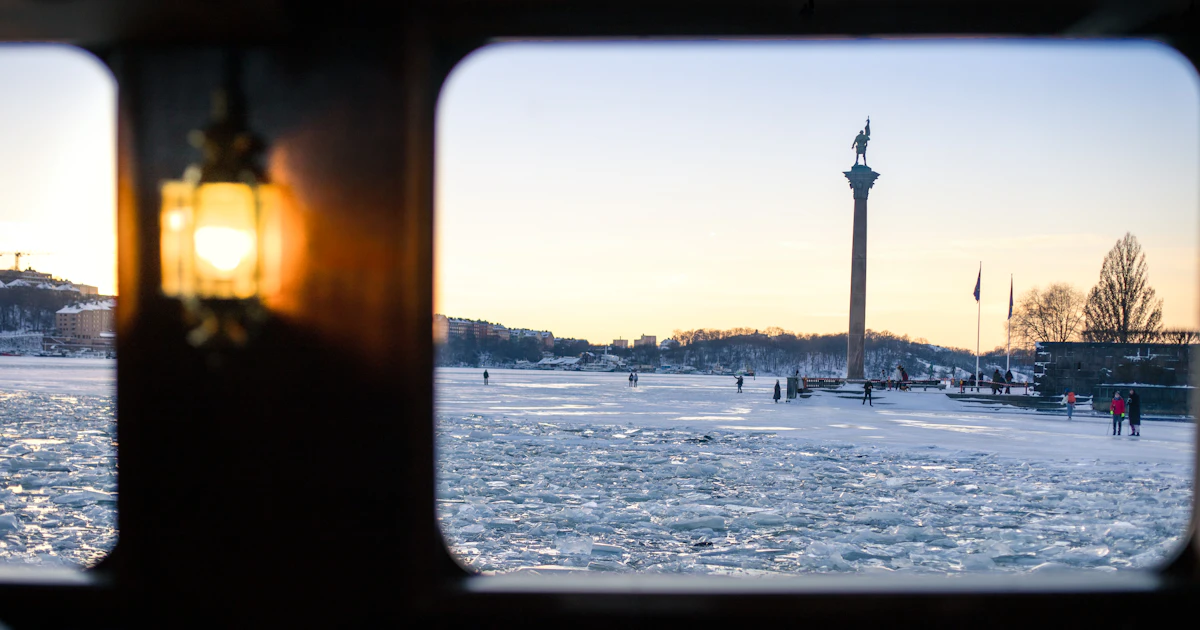 Frusen vik i Stockholm i solnedgång med människor som promenerar